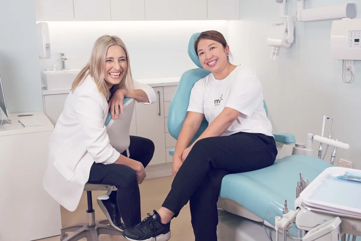 Two Milk Orthodontics team members smiling in the treatment room at the Newmarket clinic, about 15 minutes from Mission Bay