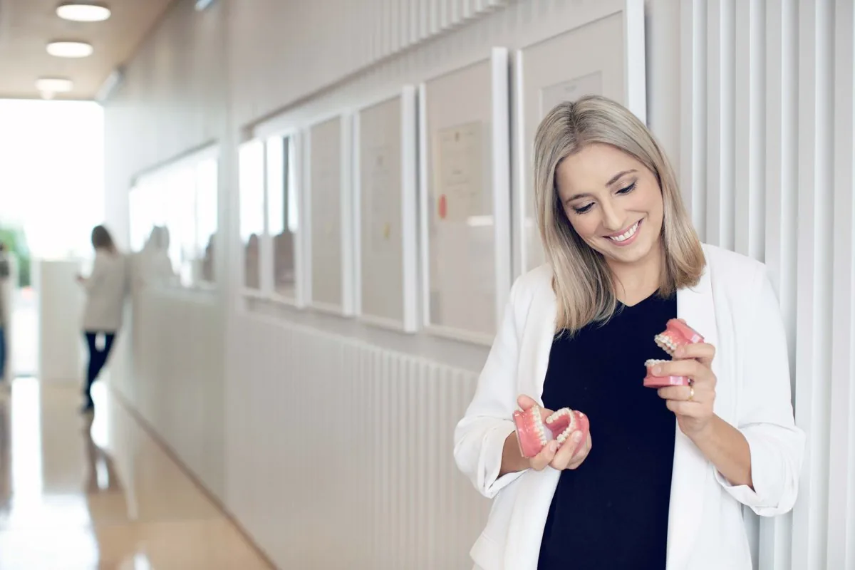 Clinician holding a clear removable appliance in the corridor at Milk Orthodontics in Newmarket
